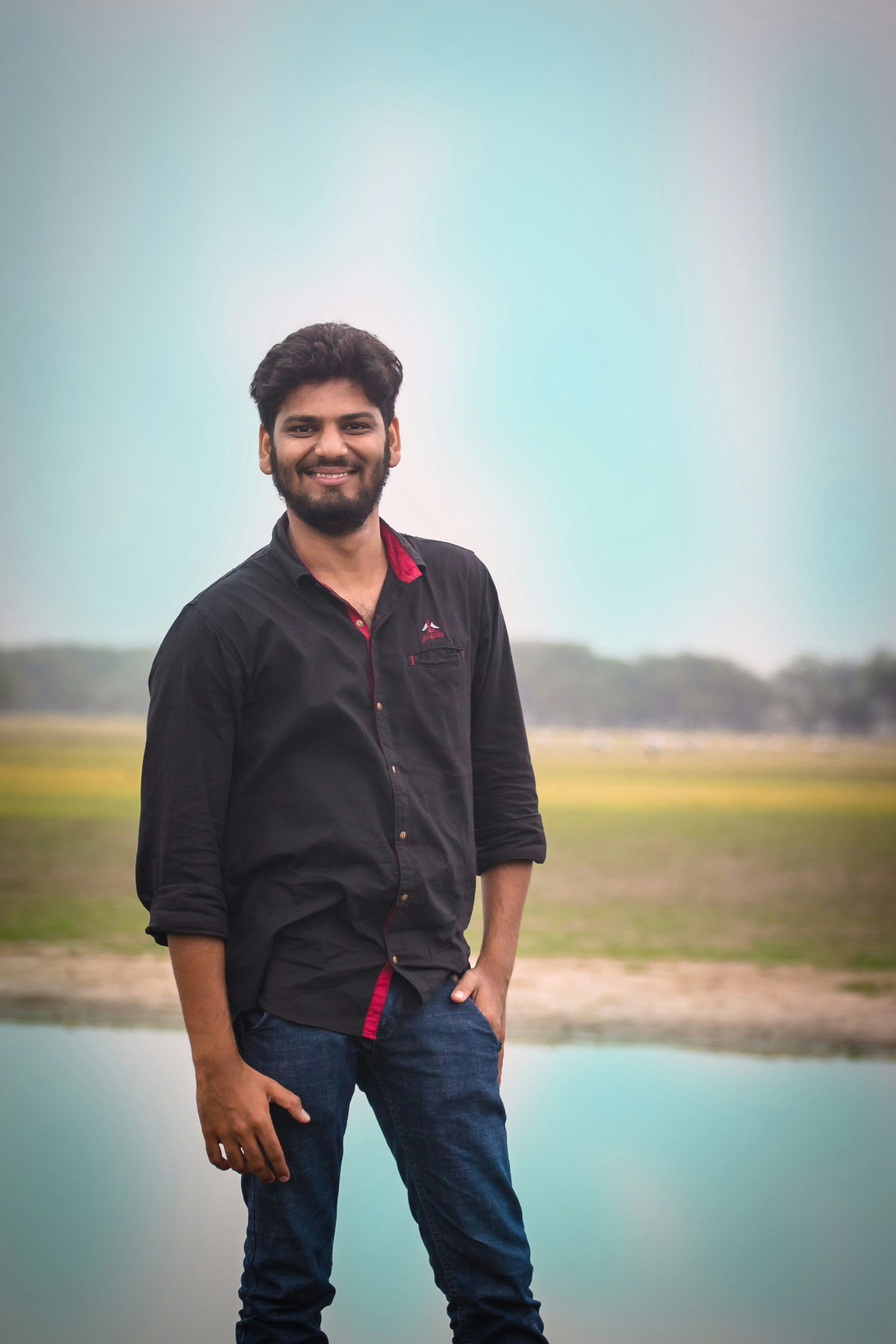 smiling man wearing black and red dress shirt